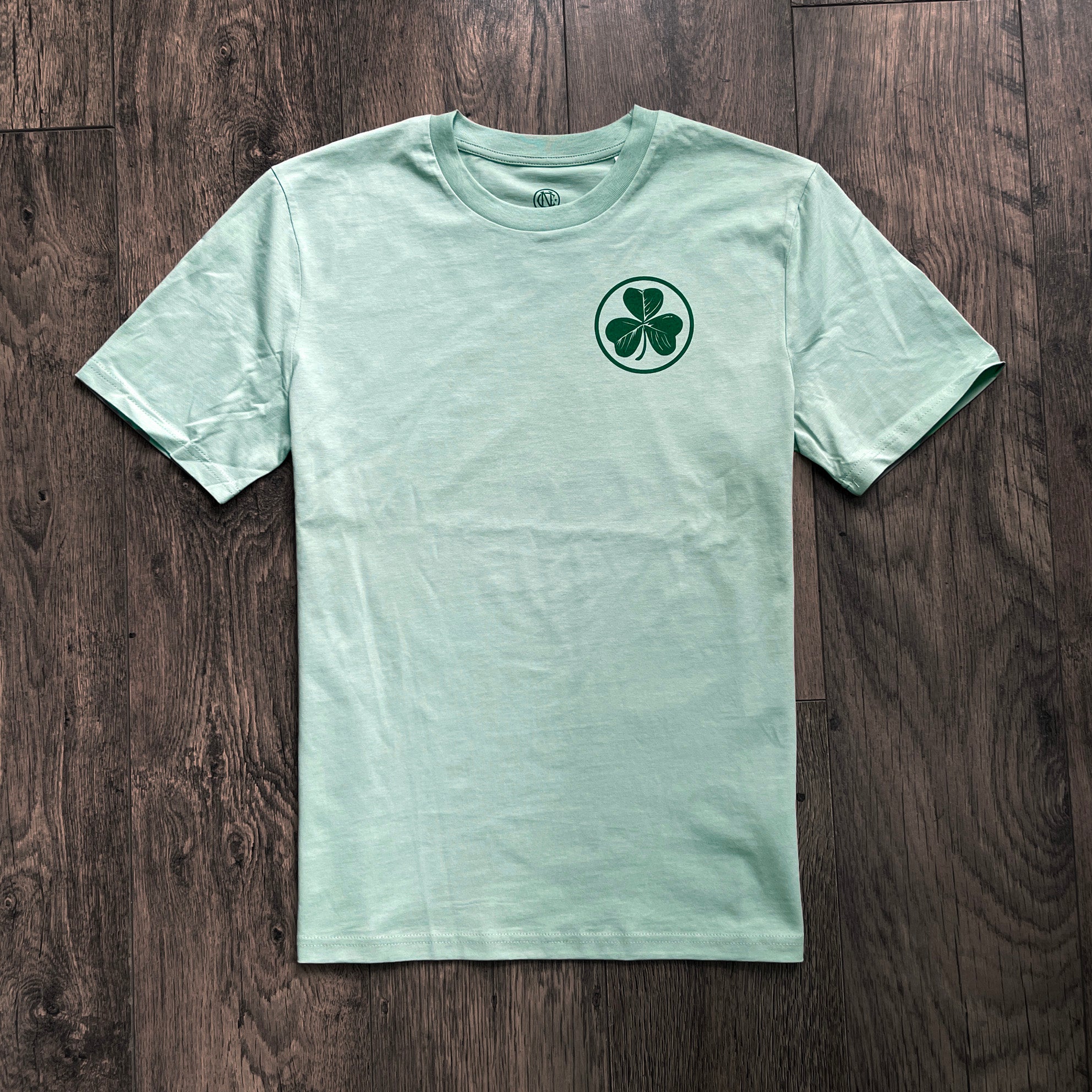 Light green Ireland mens fashion football t-shirt with a shamrock design on a wooden surface
